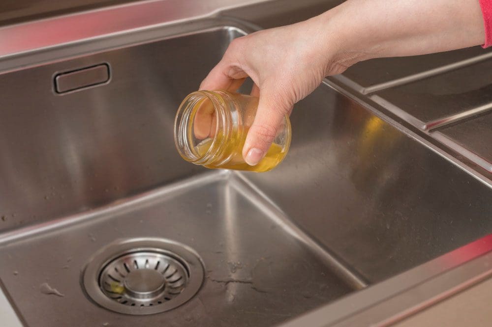 hand pouring oil down the kitchen sink Upper Arlington, OH